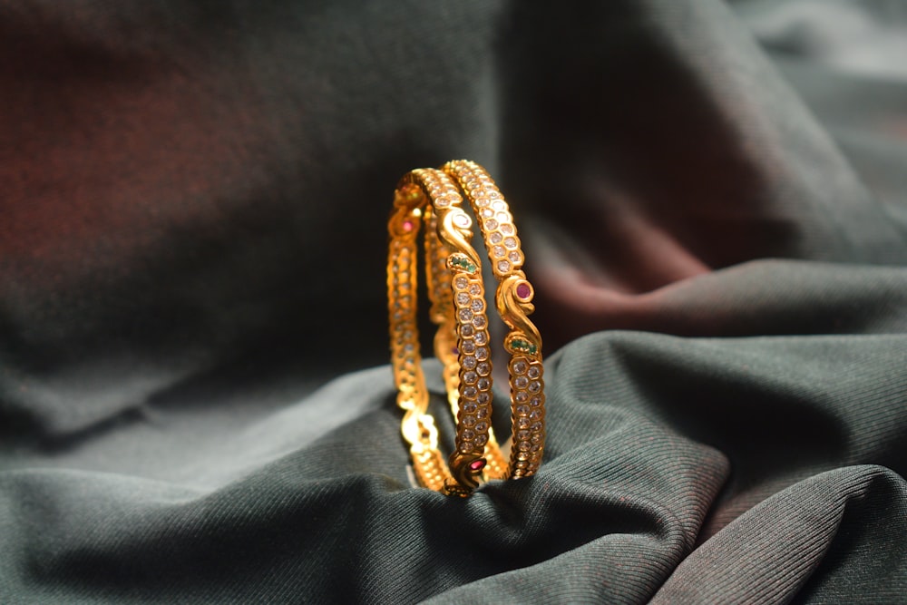 a close up of a gold bracelet on a cloth