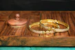 A collection of colorful bangles and matching earrings displayed on a wooden tray.