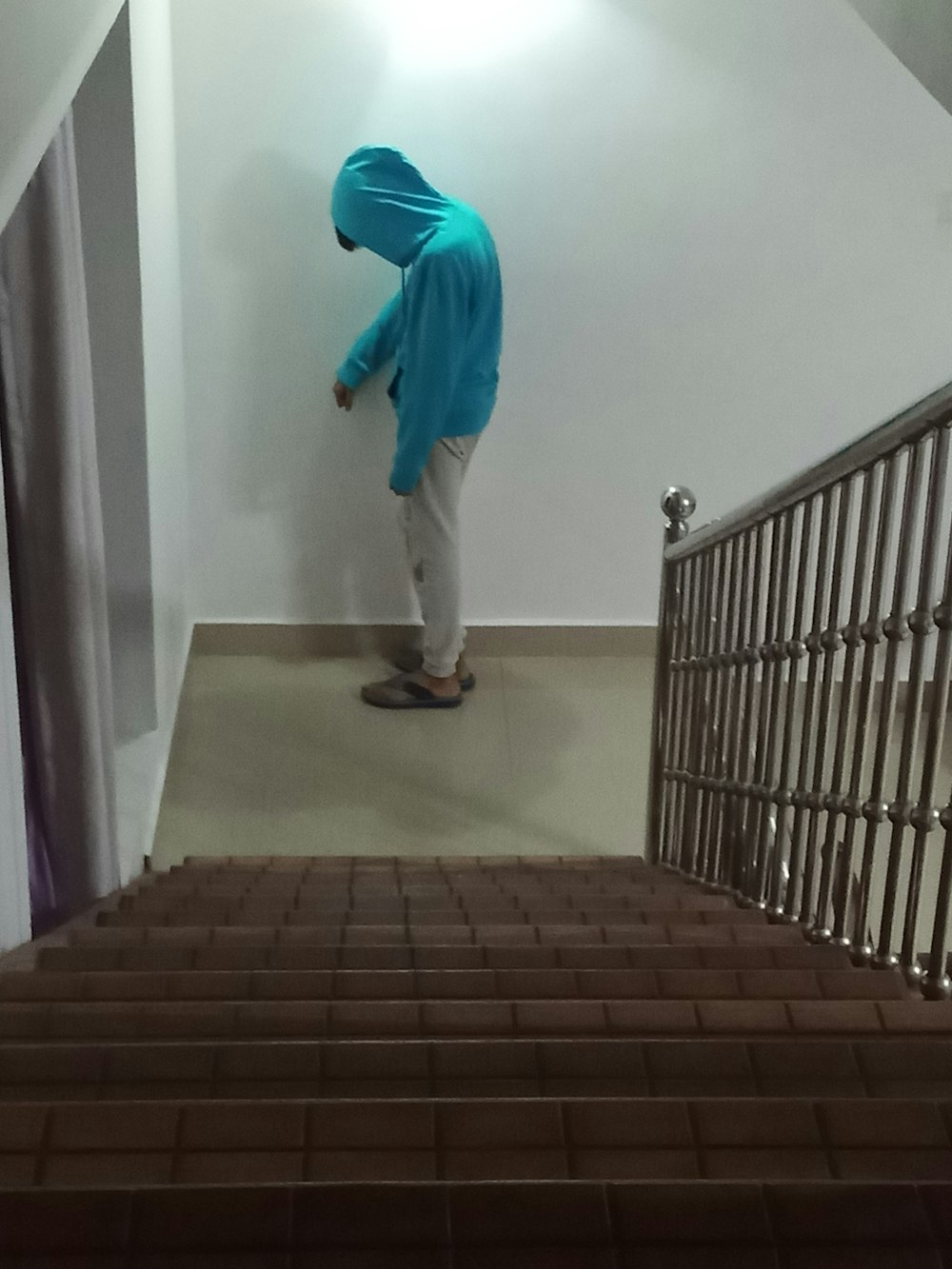 a person in a blue hoodie walking up a set of stairs