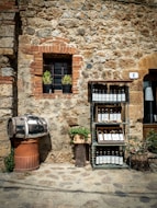 a stone building with a wine rack and a barrel