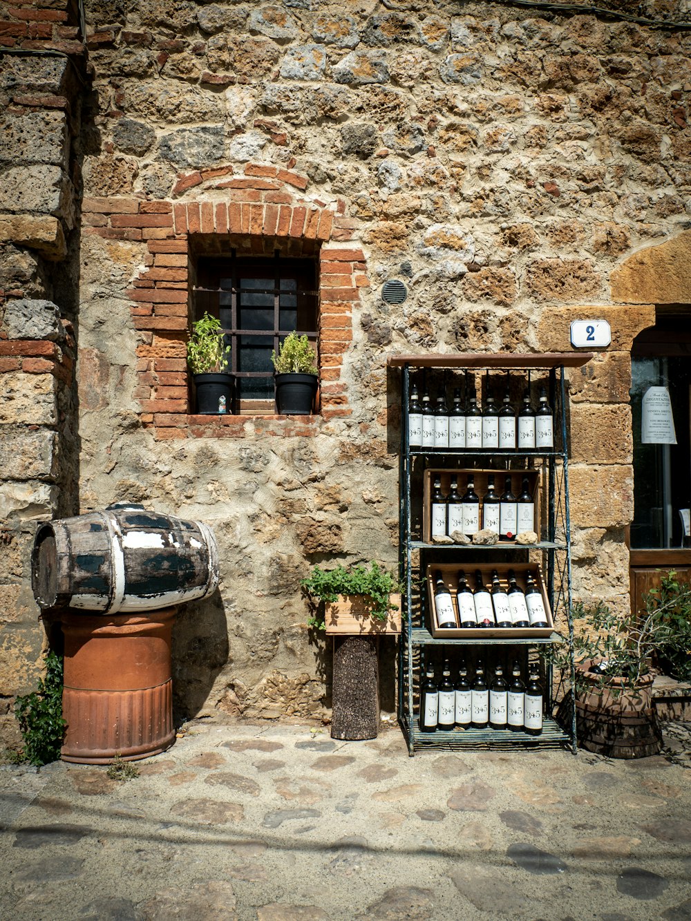 a stone building with a wine rack and a barrel