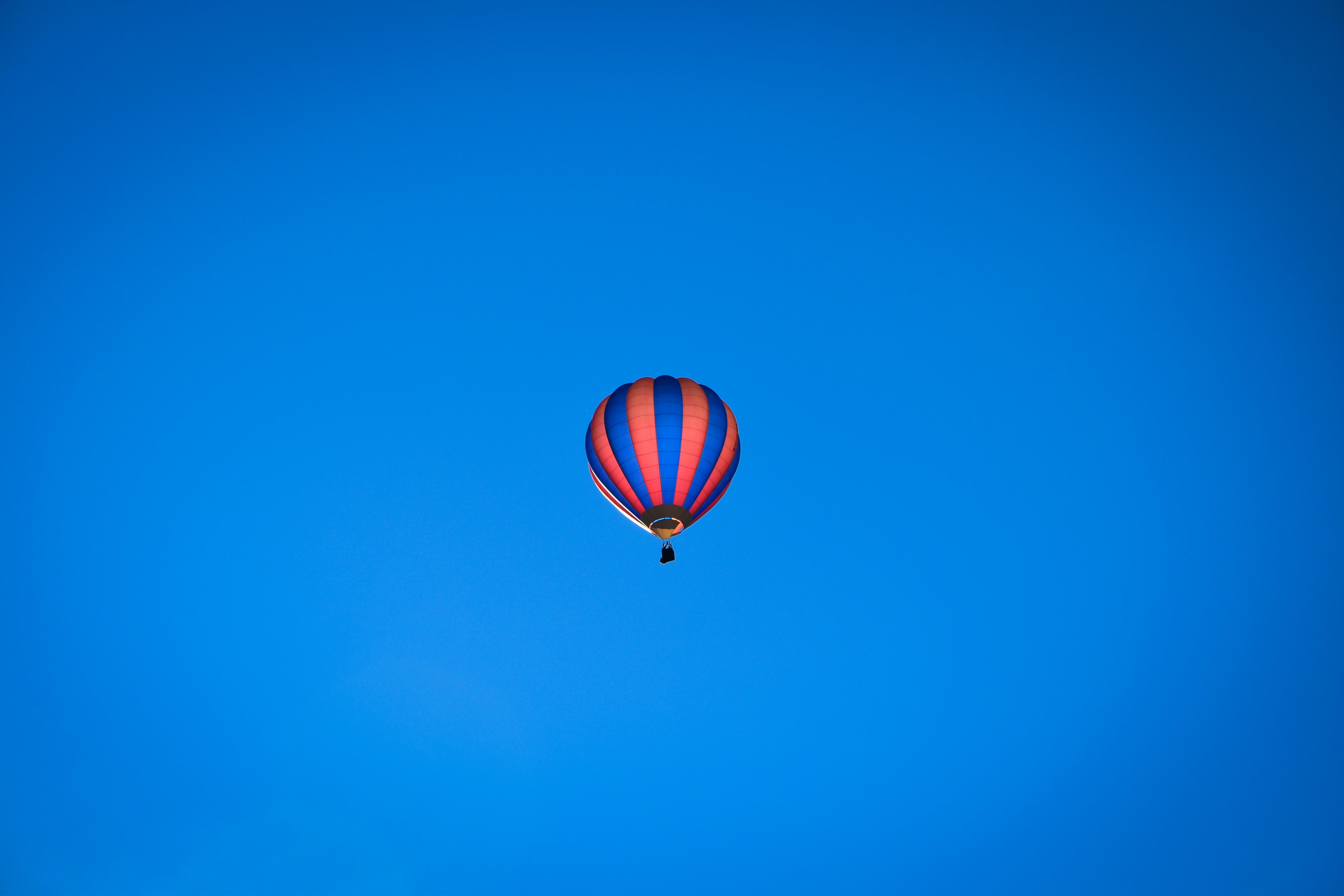 a hot air balloon flying through a blue sky