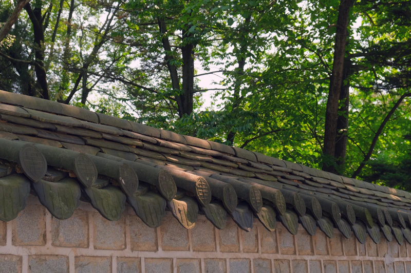 Traditional Korean hanok roof with curved tiles and intricate wooden details in Jeonju Hanok Village