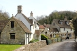 a row of houses with a stone fence in front of them