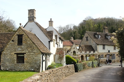 a row of houses with a stone fence in front of them