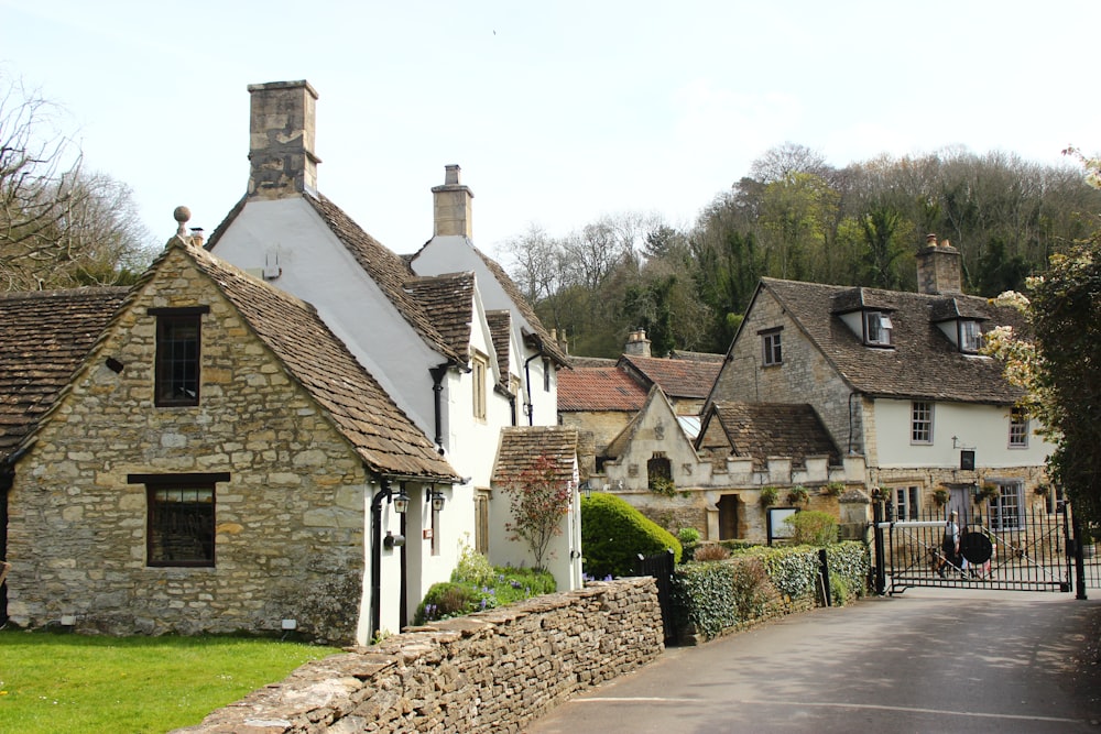 a row of houses with a stone fence in front of them