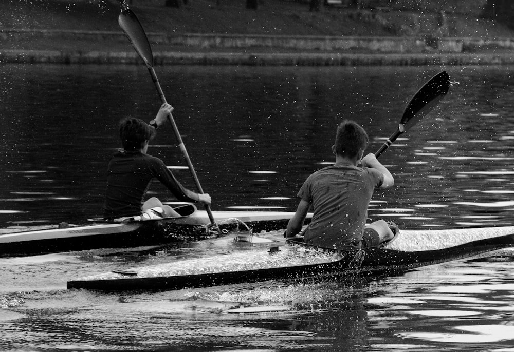 a couple of people riding on the back of a kayak