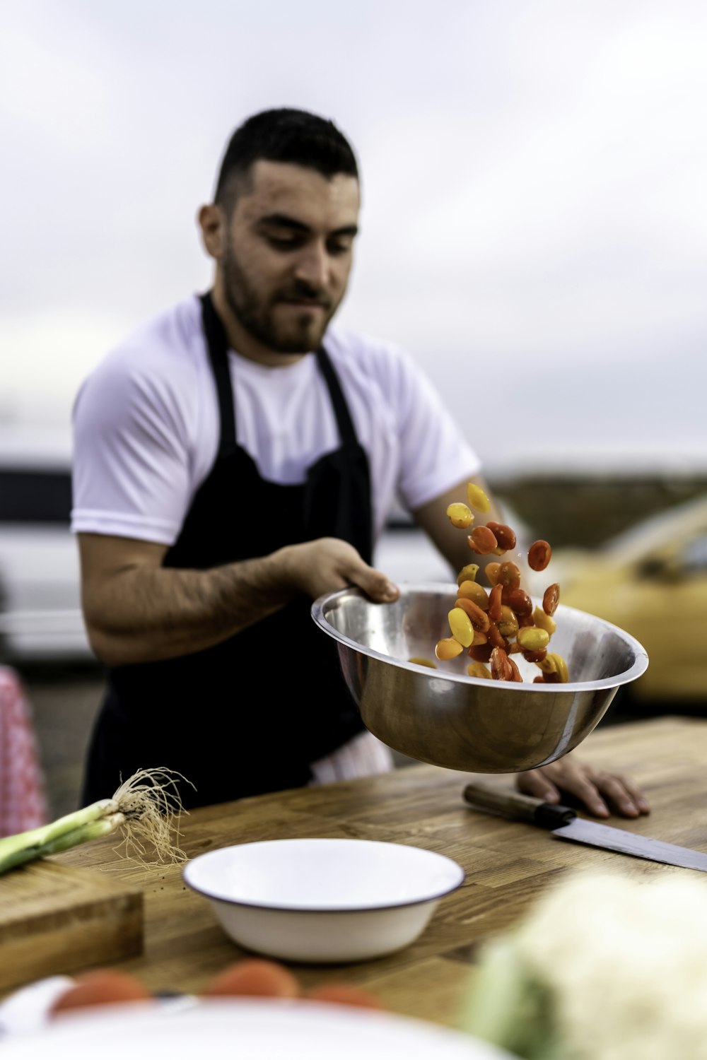 a man holding a metal bowl filled with food