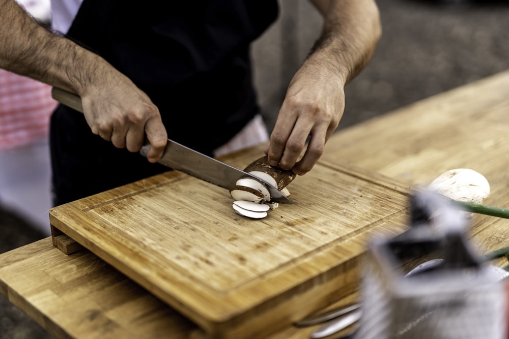 Un hombre está cortando cebollas en una tabla de cortar
