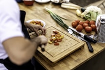 a person cutting up vegetables on a cutting board