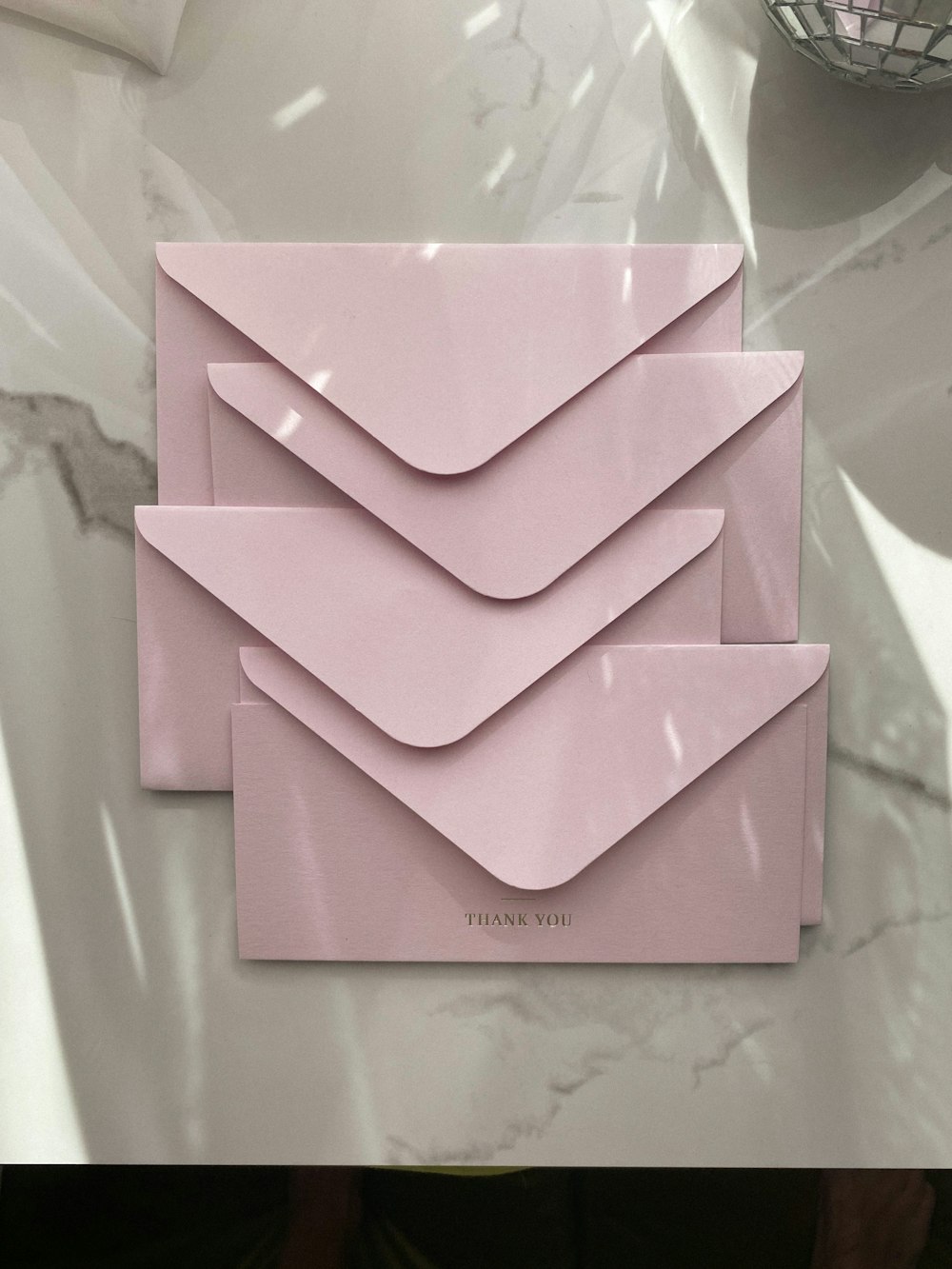 a couple of pink envelopes sitting on top of a table