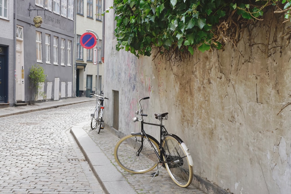 a bike leaning against a wall on a cobblestone street
