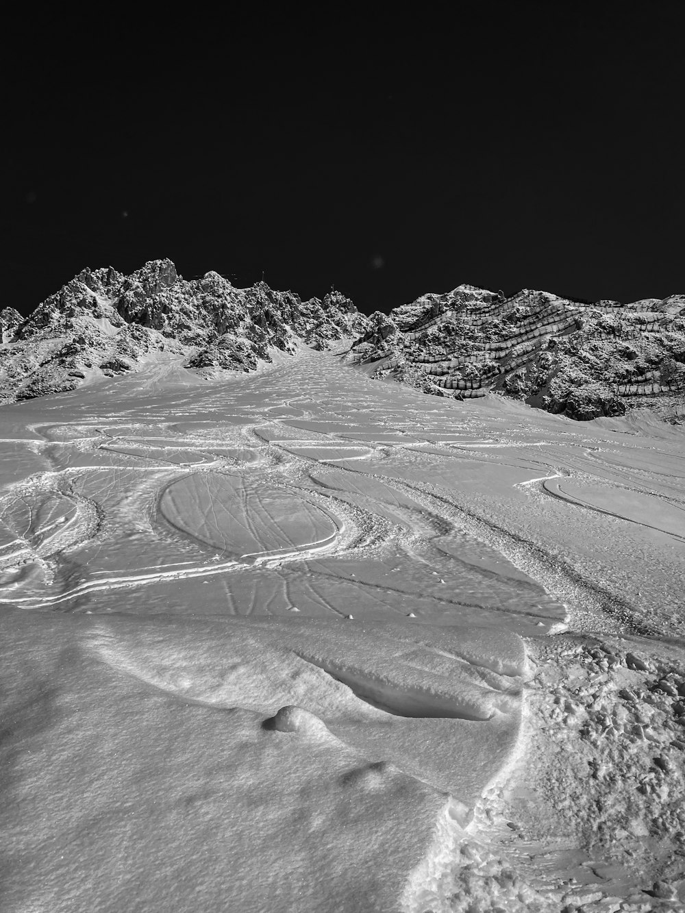 a black and white photo of a snow covered mountain