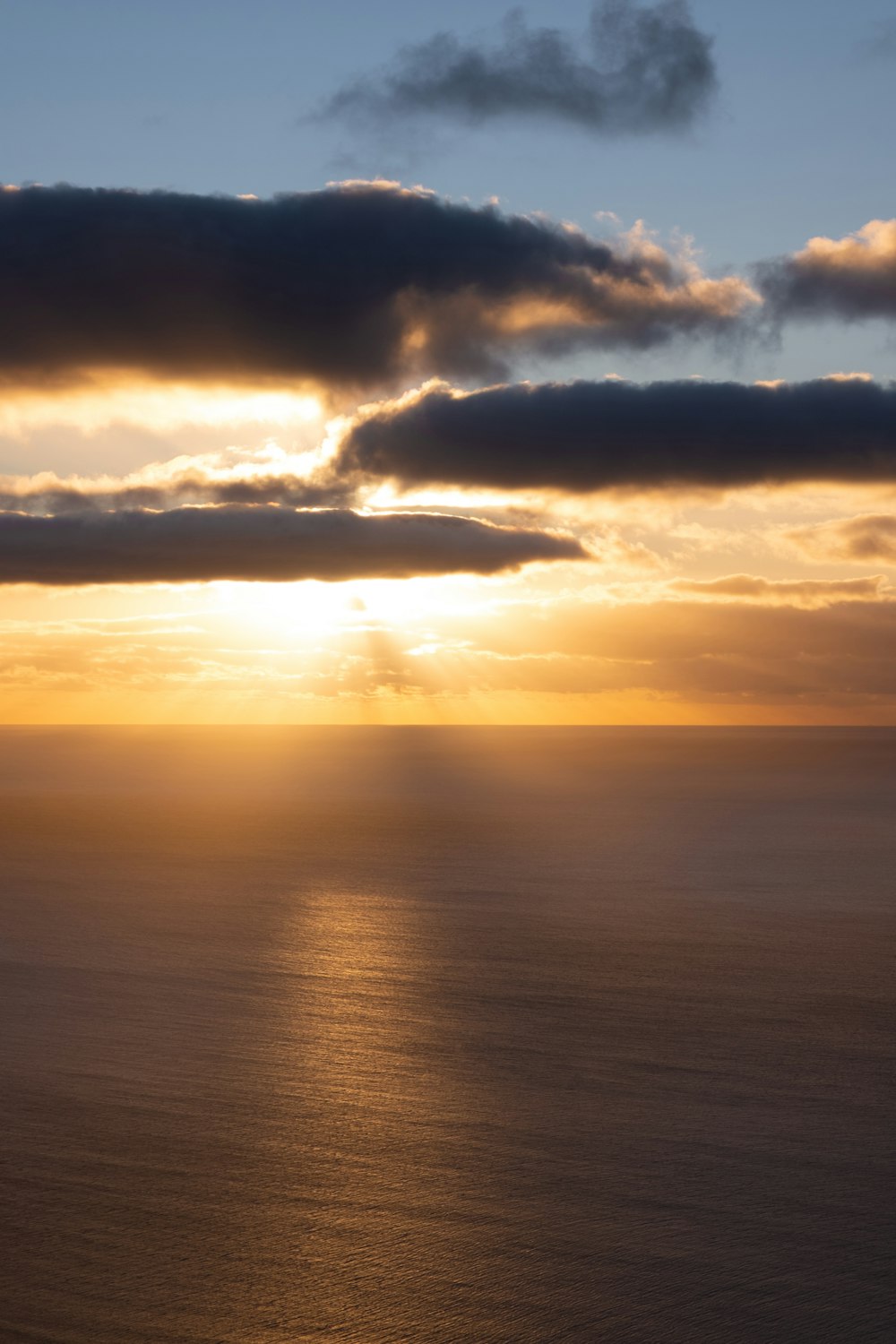 the sun is shining through the clouds over the ocean