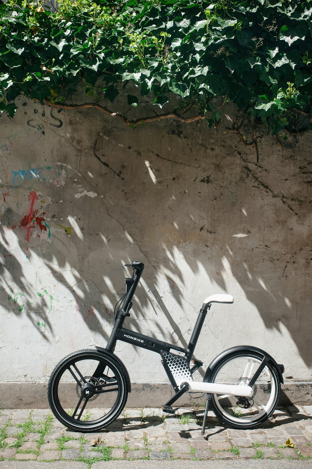 a bicycle leaning against a wall with graffiti on it
