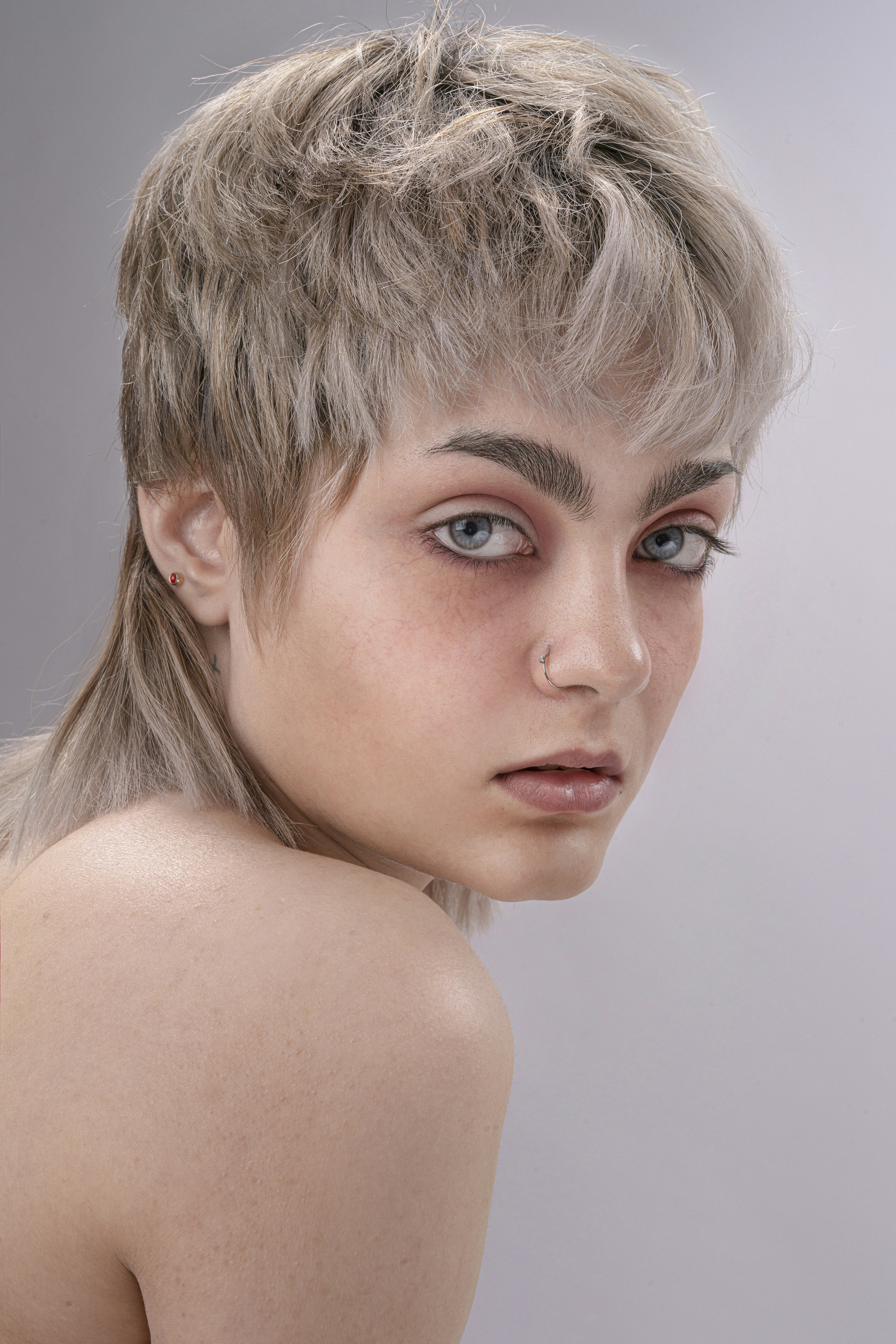 a woman with a very short hair and blue eyes