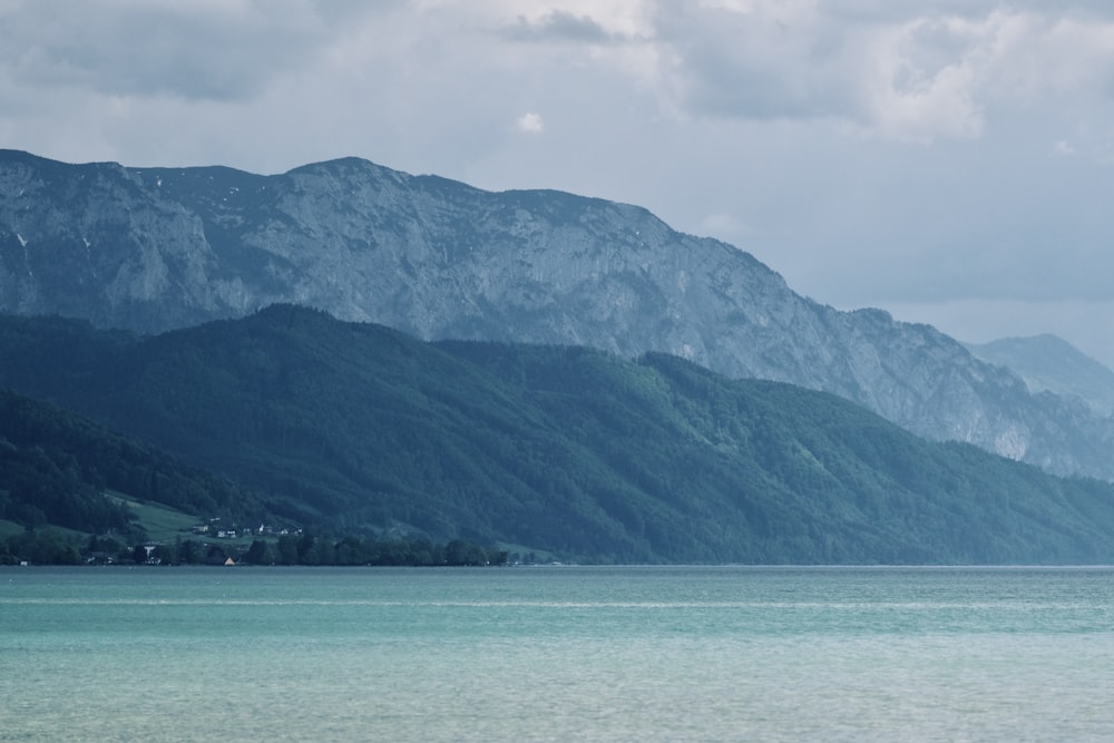 a large body of water with mountains in the background