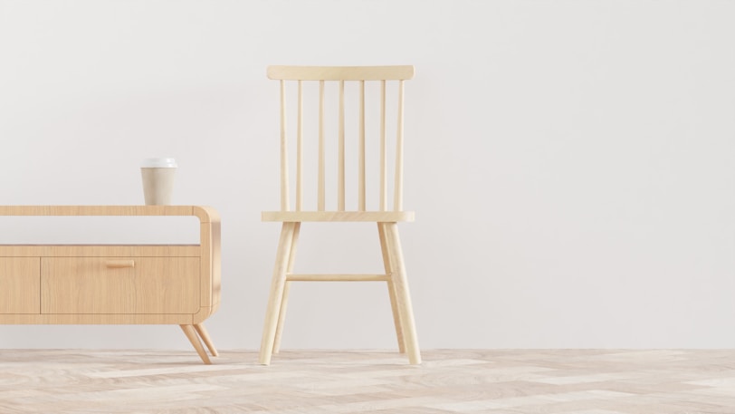 a wooden chair next to a bed in a room