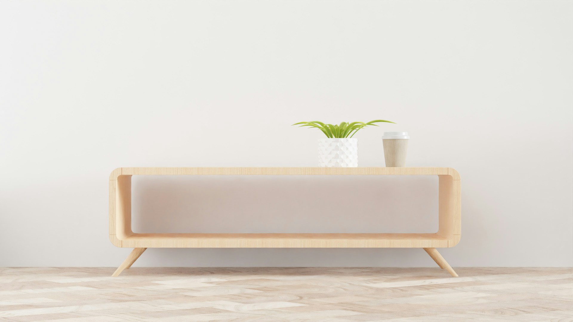 a white vase with a green plant on top of it