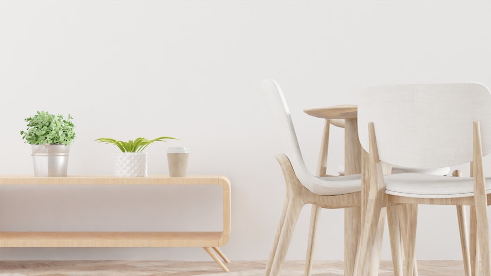 a room with a table, chairs and a potted plant