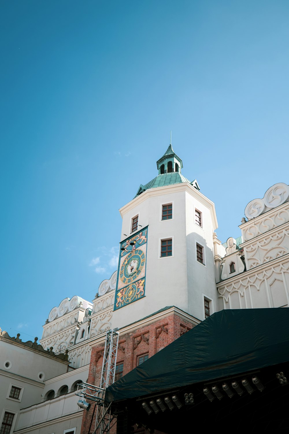 um grande edifício branco com um relógio ao seu lado