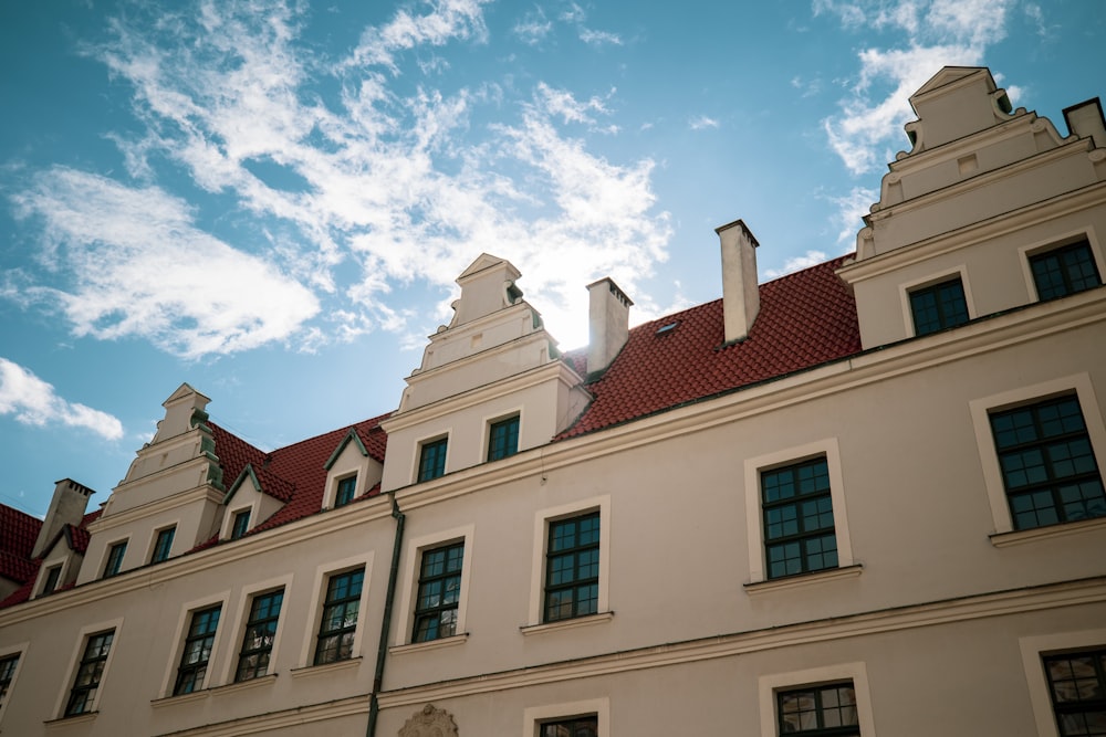 a white building with a red roof under a blue sky