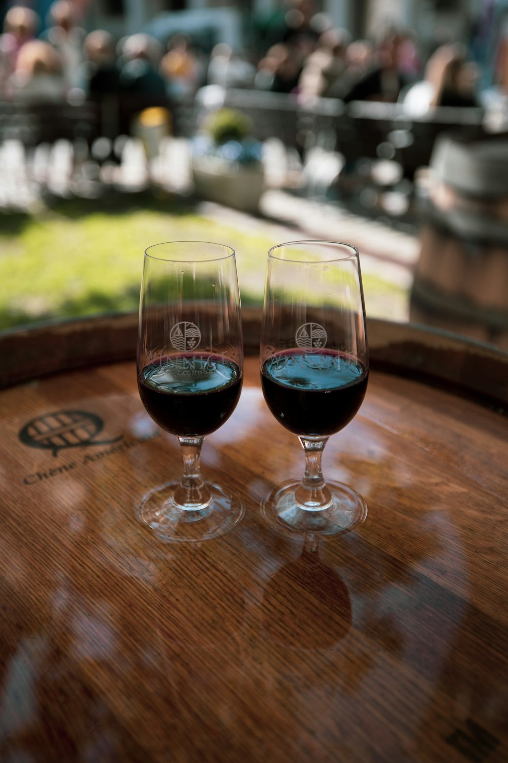 two glasses of wine sitting on top of a barrel