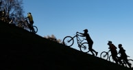 Group of riders climbing a steep hill with the Ibiza landscape in the background.