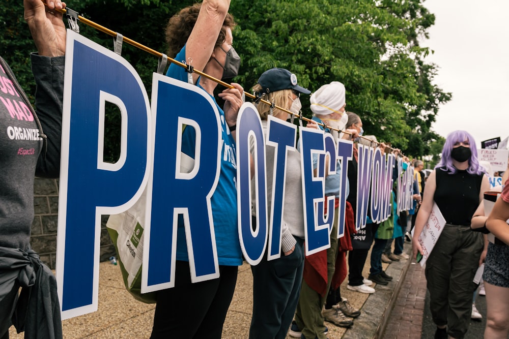 a group of people standing in front of a sign