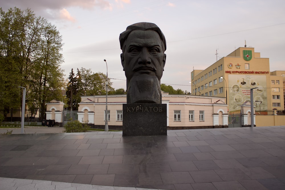 a statue of a man's head in front of a building