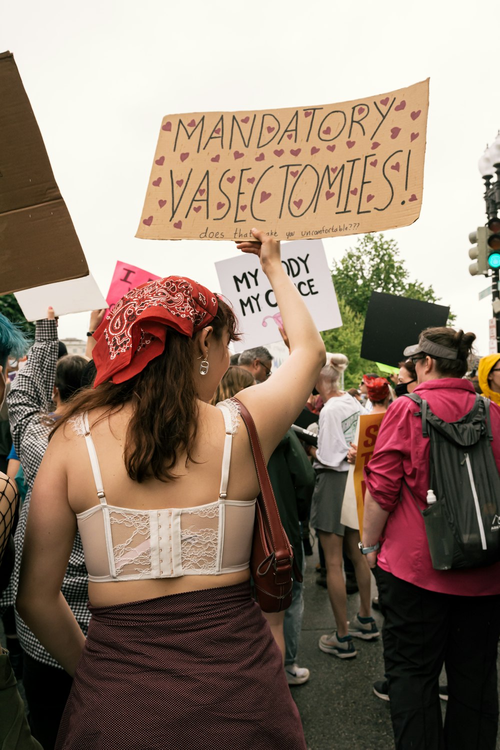 a group of people standing next to a woman holding a sign