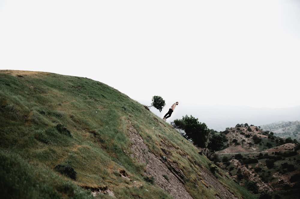 a couple of people standing on top of a lush green hillside