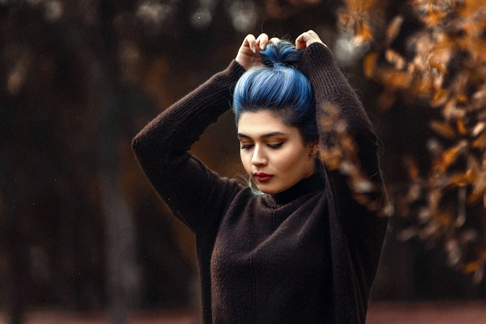 a woman with blue hair and a black sweater