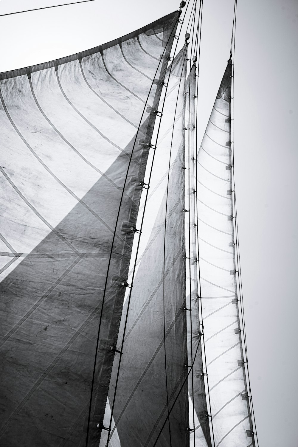 a black and white photo of the sails of a sailboat