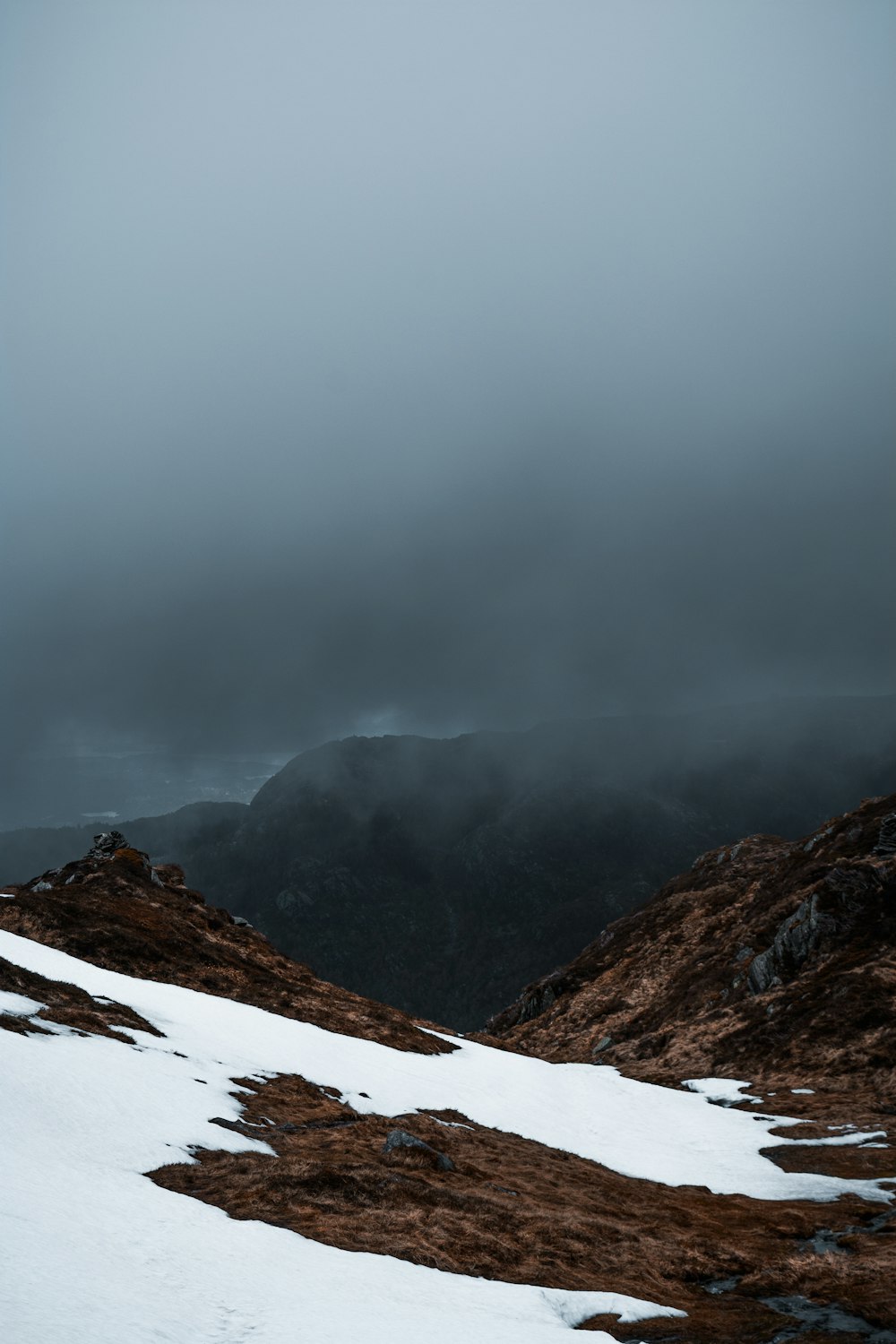 a snow covered mountain with a cloudy sky