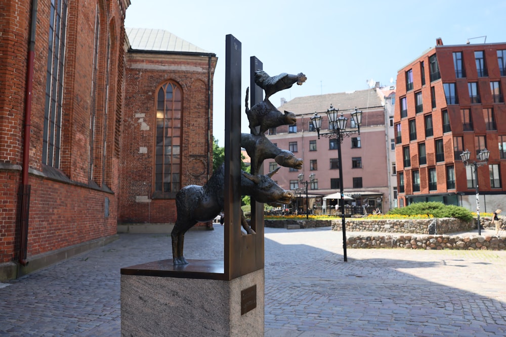 a statue of a dog on a pole in front of a building