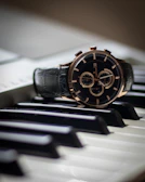 An elegant watch resting on a keyboard, symbolizing productivity and style.
