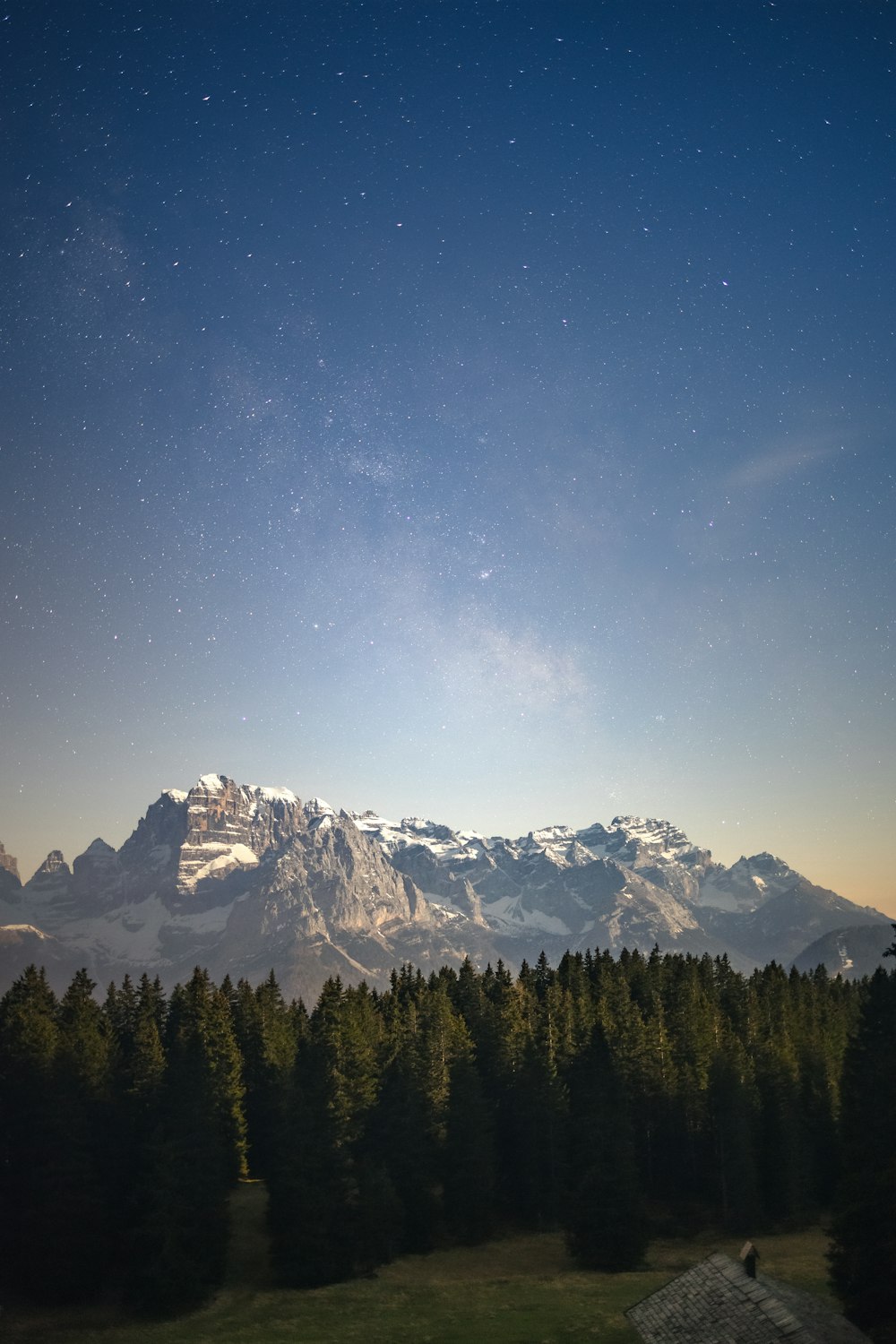 a view of a mountain range with trees in the foreground