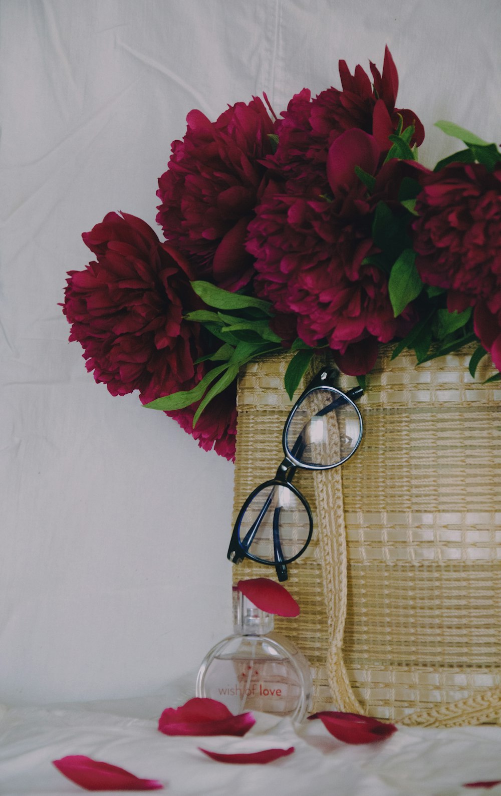 a basket with flowers and a pair of glasses