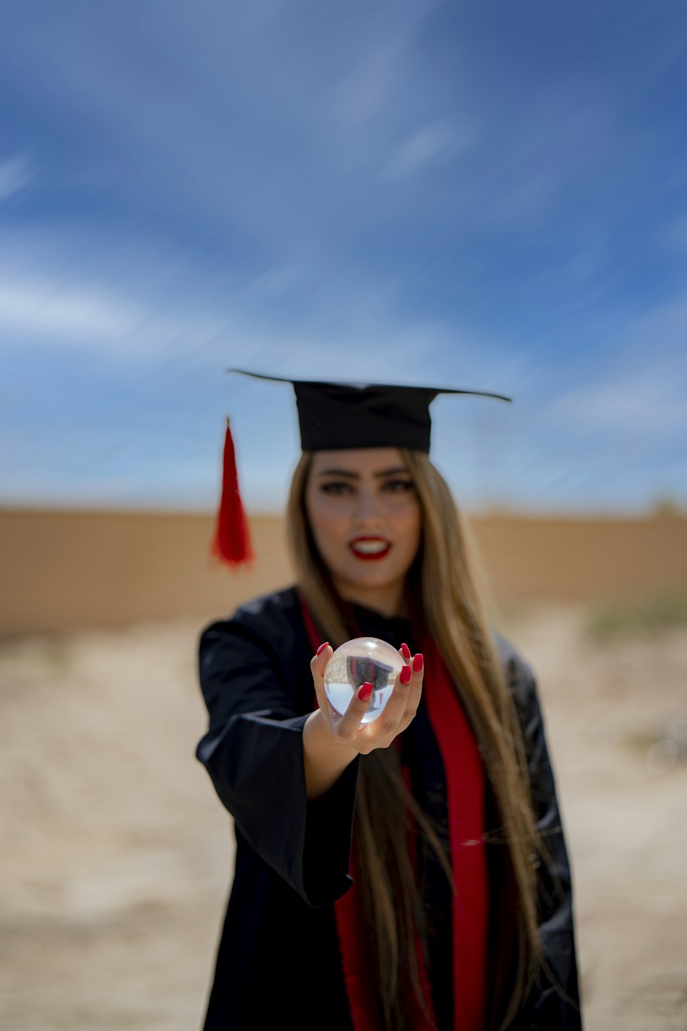 a woman in a graduation cap and gown holding a small object