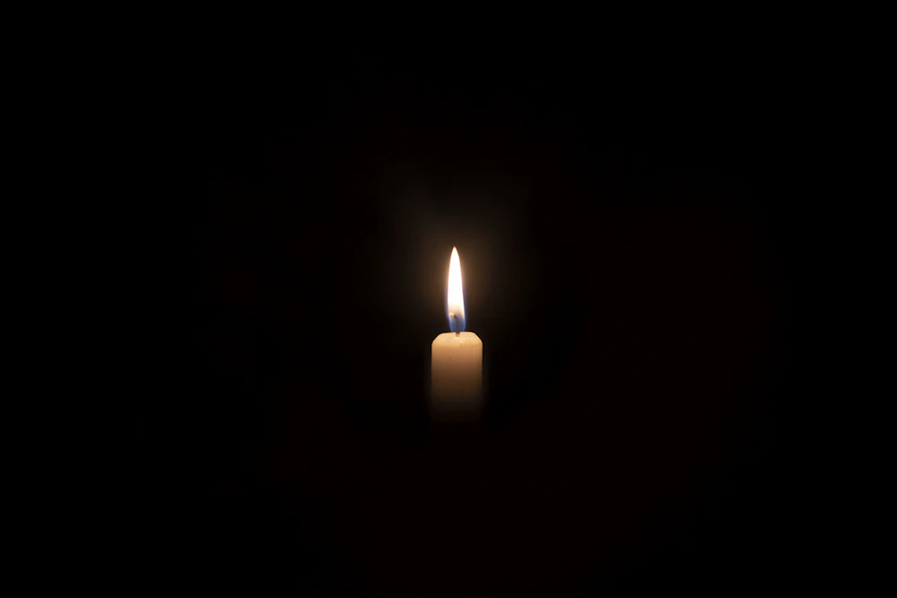A single candle glowing in the dark