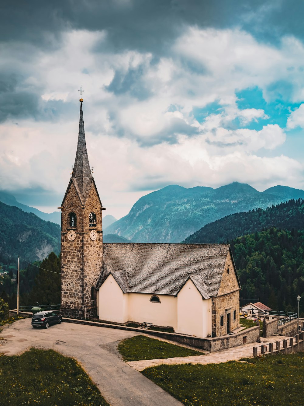 an old church with a steeple surrounded by mountains