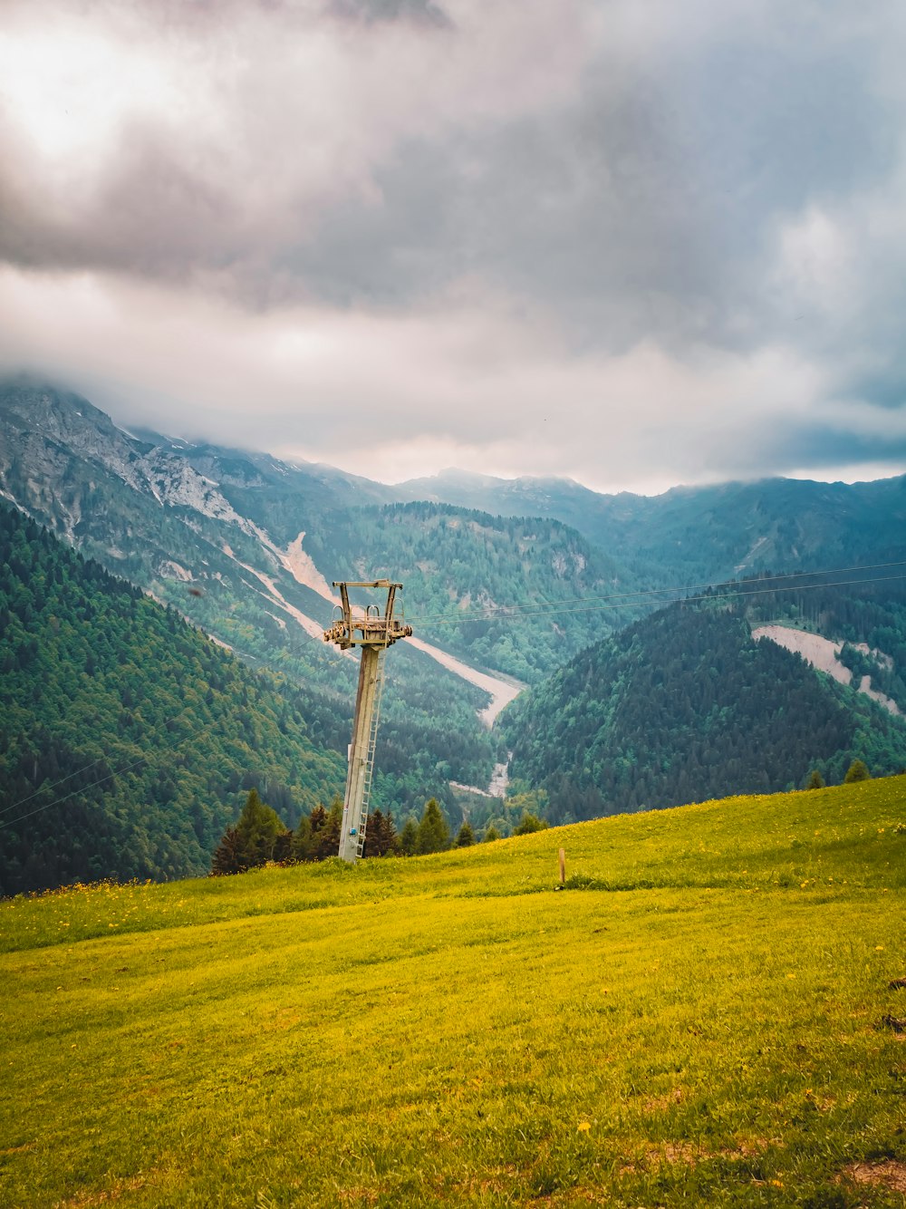 a cross on top of a hill with mountains in the background