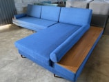 a blue couch sitting on top of a wooden table