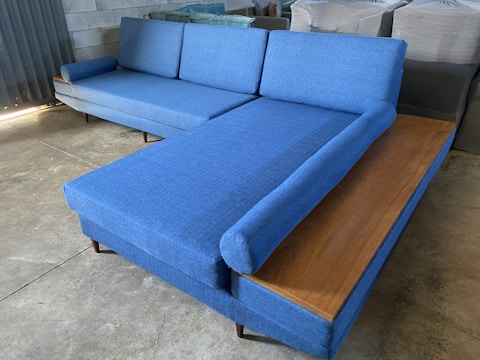 a blue couch sitting on top of a wooden table
