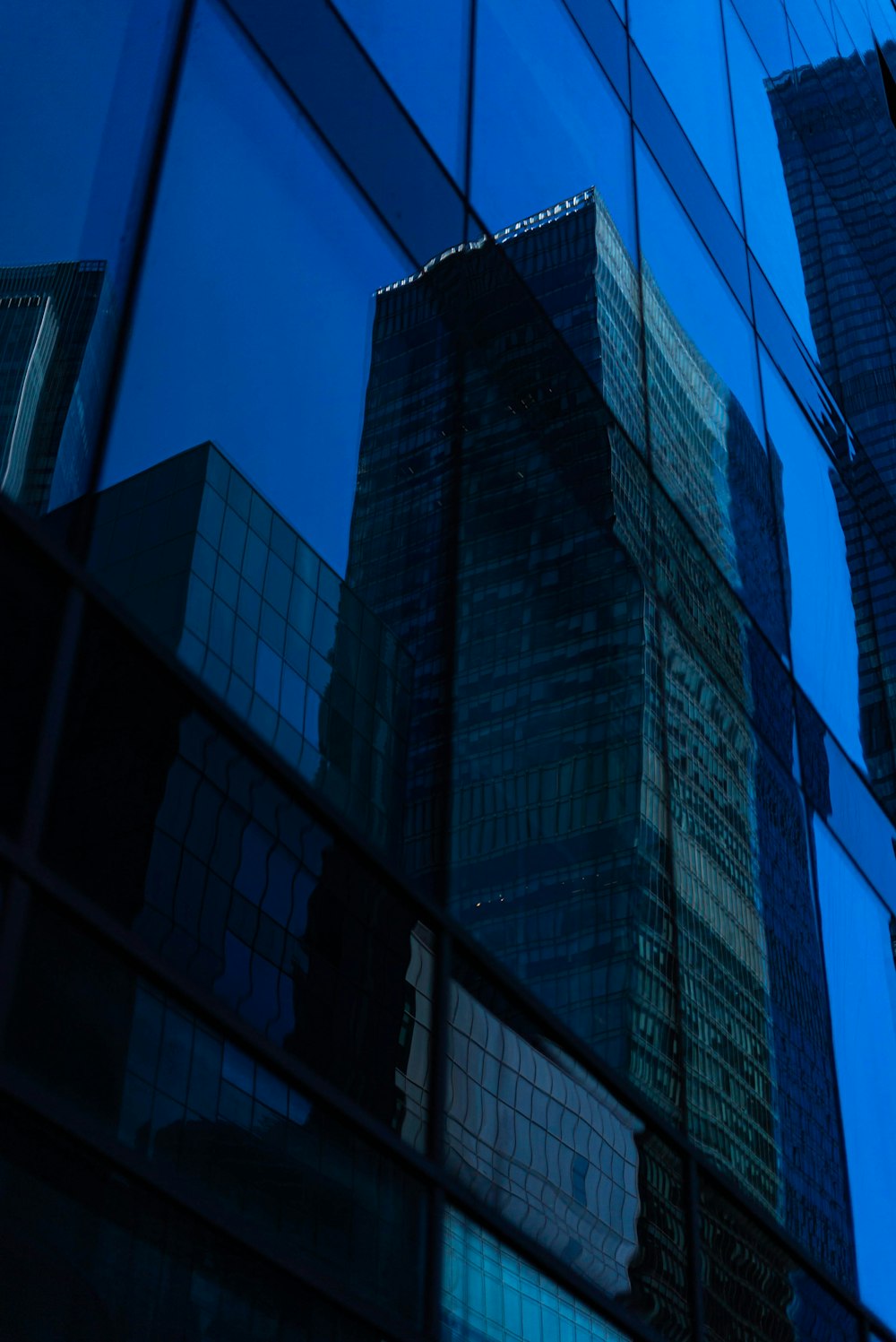 the reflection of a skyscraper in a glass building