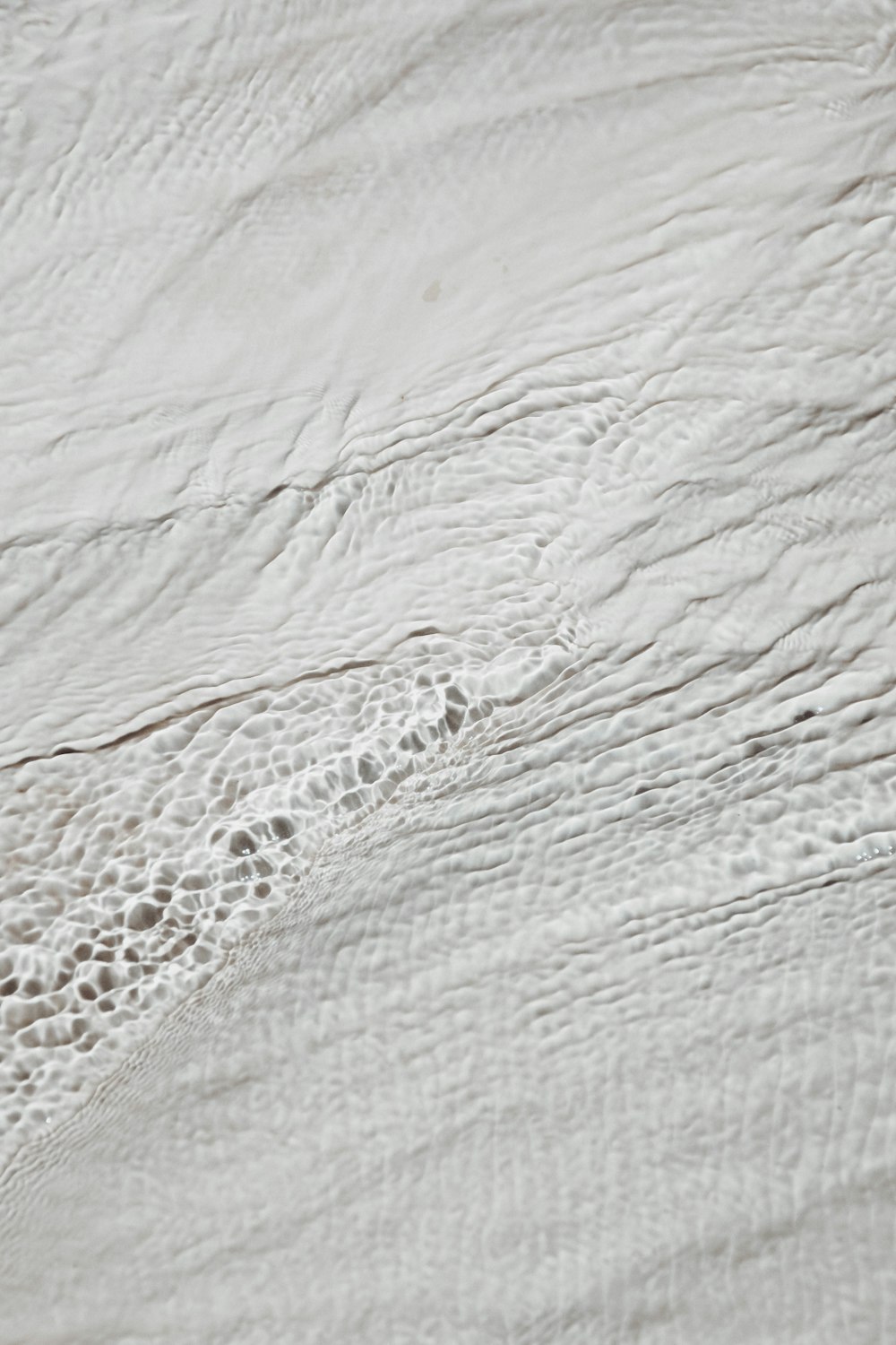 a person riding a surfboard on top of a wave covered beach