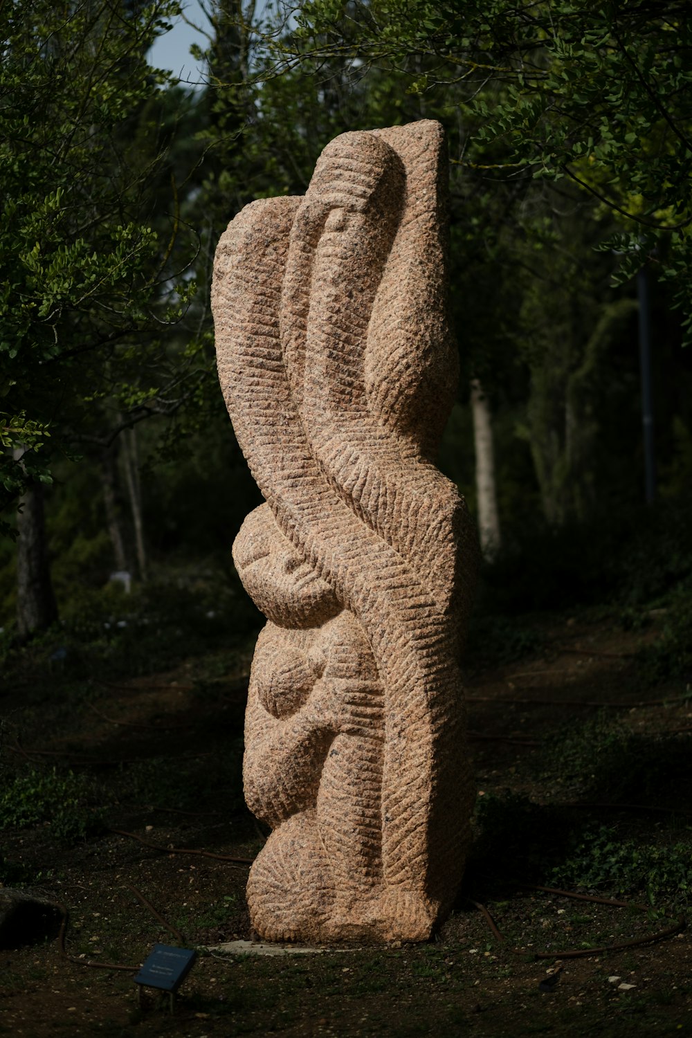 une sculpture d’une femme tenant un bébé dans ses bras