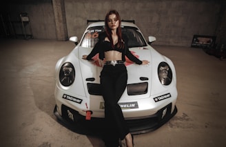 a woman sitting on top of a white car
