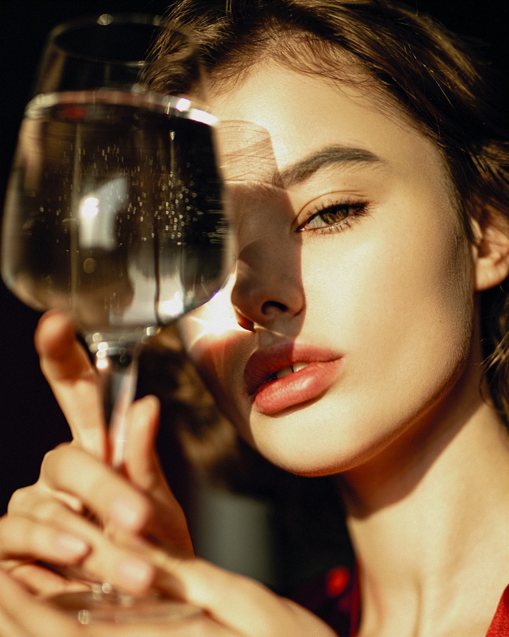 a close up of a person holding a wine glass